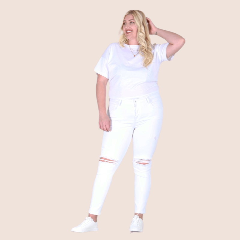 Our Reveka Plus Size Skinny Midrise White Jeans are comfortable and designed to fit like a glove. They have a mid-rise waistband, destroy knee detail, and high stretch for comfort and easy movement. 