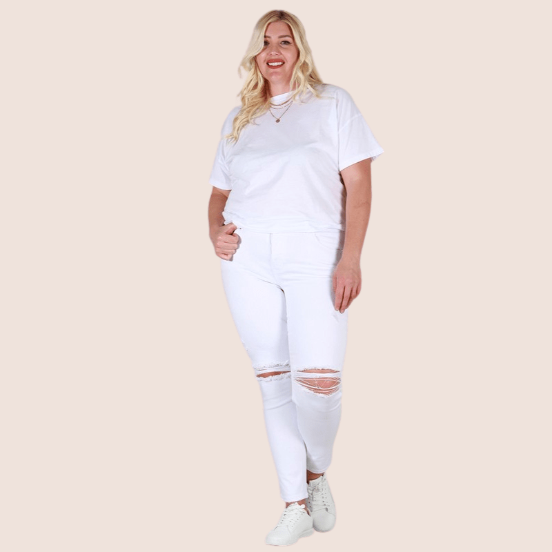 Our Reveka Plus Size Skinny Midrise White Jeans are comfortable and designed to fit like a glove. They have a mid-rise waistband, destroy knee detail, and high stretch for comfort and easy movement. 