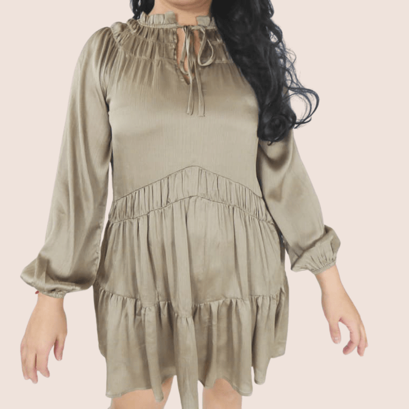 This Shimmer Baby Doll dress features a relaxed fit, round neckline, ruffle hem, and hidden pockets. It has balloon sleeve details and a gathered waist with ruffles.