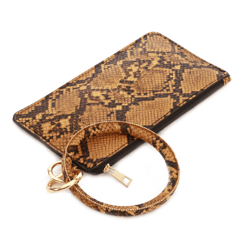 This mustard snake print vegan leather keychain wallet is perfect for the minimalist and on-the-go. The keyring feature attaches to your keys, but also slides off and transforms into a wallet.